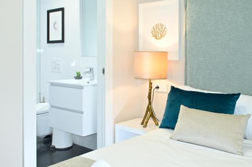 een slaapkamer met een bed, een wastafel en een lamp bij Holihome Rambla 24 in Alicante