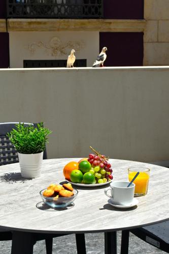 a table with two plates of fruit on top of it at Holihome Rambla 24 in Alicante