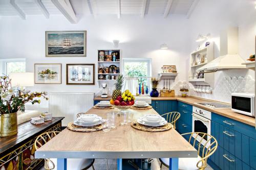 a kitchen with blue cabinets and a table with fruits on it at Villa Nautilus in Áfra