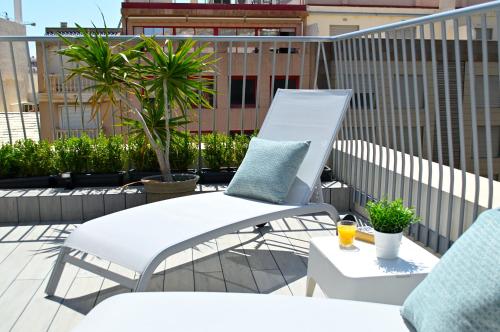a white chair and a table on a balcony at Holihome Rambla 24 in Alicante