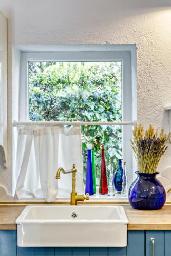 a kitchen window with a sink and vases on a counter at Villa Nautilus in Áfra