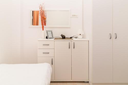1 dormitorio blanco con armarios blancos y 1 cama en Apartment Mini Condo Meljine, en Herceg-Novi