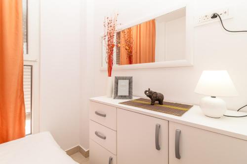 eine weiße Kommode mit einer Lampe und einem Spiegel in der Unterkunft Apartment Mini Condo Meljine in Herceg-Novi