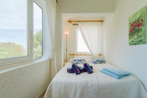 a bedroom with two blue pillows on a bed with a window at Apartment Casa Alessandro mit Meerblick in Carvoeiro