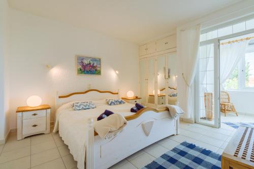 a bedroom with a white bed and a large window at Apartment Casa Alessandro mit Meerblick in Carvoeiro