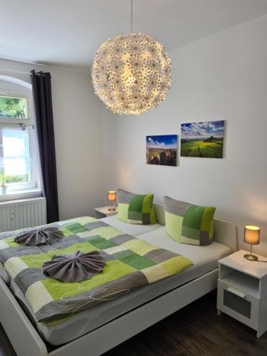 a bedroom with a bed and a chandelier at Apartmenthaus Luise in Bad Schandau