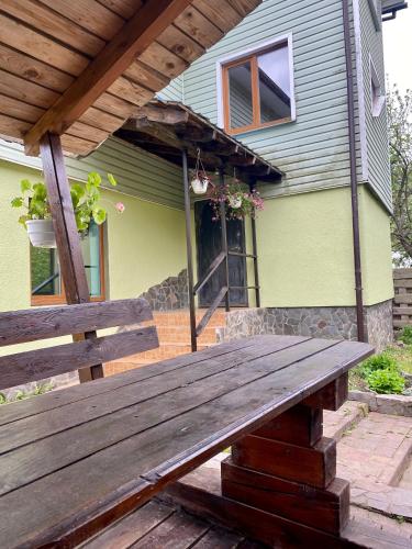 a wooden bench sitting in front of a house at Medova Hata in Verkhnyaya Rozhanka
