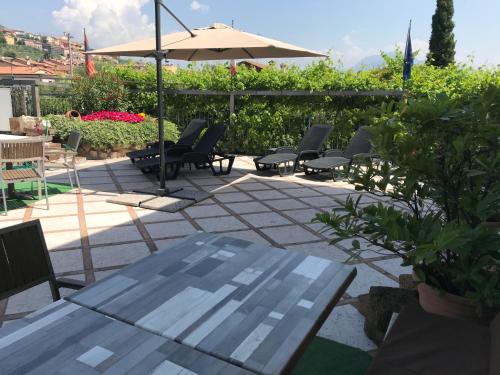 a patio with a table and chairs and an umbrella at Borgo Piccolo in Cavaion Veronese