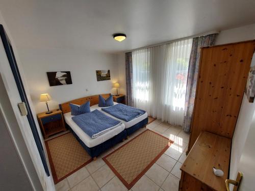 1 dormitorio con cama con sábanas azules y ventana en Apartment Feodora en Sassnitz