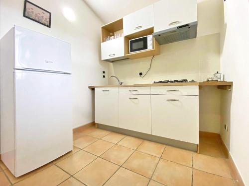 a kitchen with white cabinets and a refrigerator at Giannì Holiday Home - Vesuvio/Pompei in Terzigno