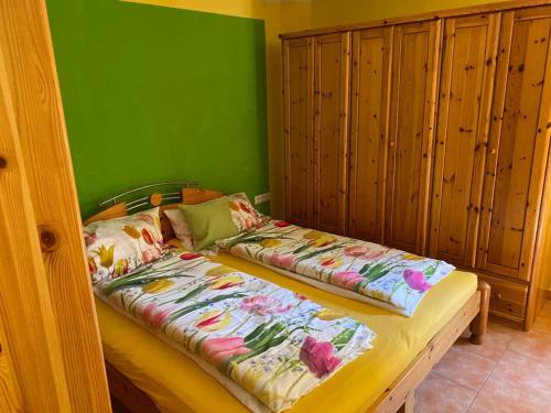 2 Betten in einem Zimmer mit grüner Wand in der Unterkunft Apartment Orlitsch in Klagenfurt am Wörthersee