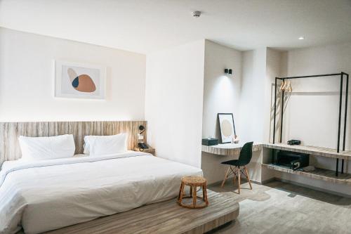 a bedroom with a large white bed and a desk at HOMITEL Bangkok in Bangkok