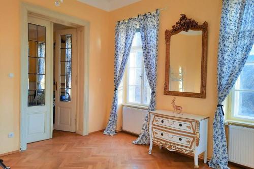 a room with a mirror and a dresser and windows at Sisi-Schloss Rudolfsvilla - Quartett in Reichenau