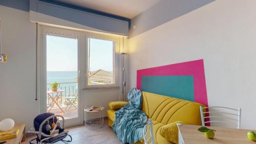 ピエトラ・リーグレにあるBabyaccommodation Family Panoramic Iのリビングルーム(黄色のソファ付)が備わり、海の景色を望めます。