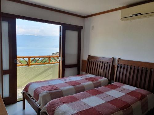 Postel nebo postele na pokoji v ubytování Bangalô com vista para o mar no condomínio Yacamim Ilhabela praia do Curral