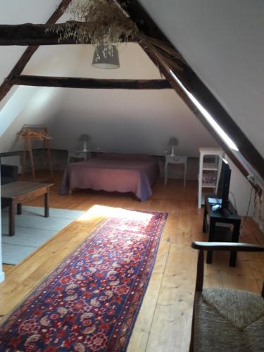 um quarto no sótão com um tapete num piso de madeira em Charme, jardin et vue panoramique en plein coeur de St-Cirq em Saint-Cirq-Lapopie