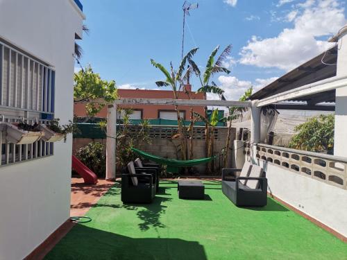 a patio with a hammock and a playground at La Caseta de Jose in Mareny Barraquetas