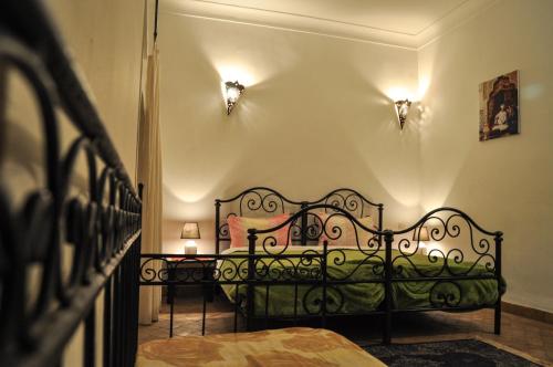 um quarto com uma cama preta e duas mesas em Riad Mandalay em Marrakech