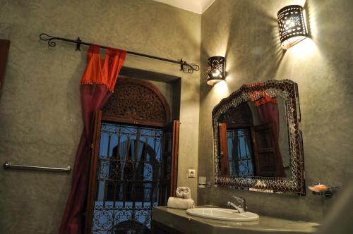 uma casa de banho com um lavatório, uma janela e um espelho. em Riad Mandalay em Marrakech