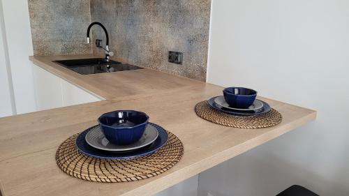 two blue cups and saucers sitting on a kitchen counter at Enklawa Mielno-Unieście przy plaży in Unieście