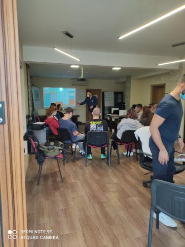 a group of people sitting in chairs in a room at Hotel Fobra in Podgorica