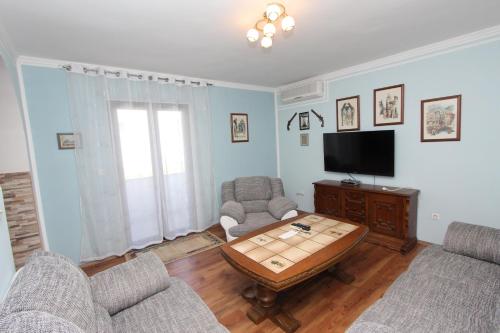a living room with a table and chairs and a tv at M&R apartmani Rovinj in Rovinj