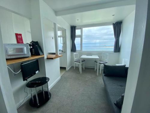 a living room with a couch and a television at Coast Accommodation in St Ives