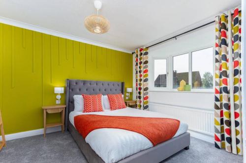a bedroom with a bed and a yellow wall at Avella by the Park in Lytham St Annes