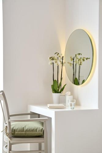 a white desk with a chair and a mirror at Stelia Mare Boutique Hotel in Naousa