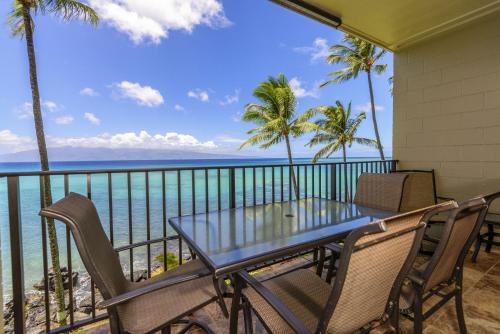 a balcony with a table and chairs and the ocean at Noelani 304 3Bdrm 2,5 Bath Condo in Kahana