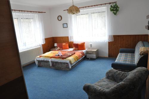 1 dormitorio con cama, sofá y ventanas en Penzion Zelinka en Kořenov