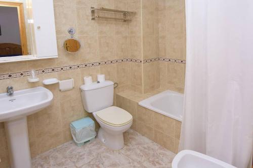 uma casa de banho com um WC, um lavatório e uma banheira em HOTEL DON FELIPE em Carboneras