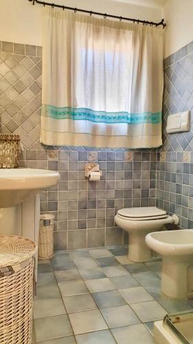 a bathroom with a toilet and a shower curtain at Fiordaliso Aurora in Olbia
