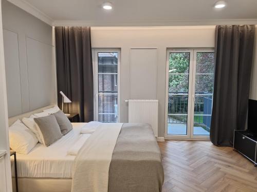 1 dormitorio con 1 cama grande y balcón en Apartamenty Leśne - visitopl, en Świnoujście