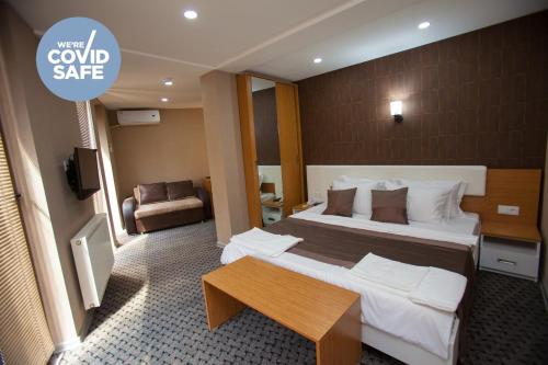 een hotelkamer met een groot bed en een tafel bij Hotel Voyager in Tbilisi City