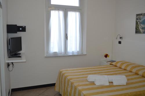 a bedroom with a bed with two towels on it at Hotel Delle Rose in Bonassola