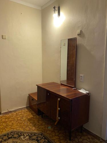 a bathroom with a wooden dresser and a mirror at В Самом центре in Myrhorod