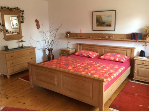 Schlafzimmer mit einem Bett mit einer roten Bettdecke in der Unterkunft Ferienwohnung Hörmann in Langdorf