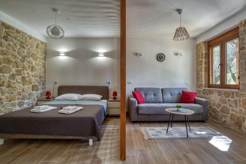 sypialnia z łóżkiem i kanapą w obiekcie Stonehouse in Olives w Ulcinju