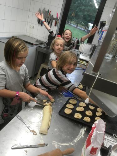 a group of girls standing in a kitchen making cookies at Pension Haus Fürstenberg in Grünhain-Beierfeld