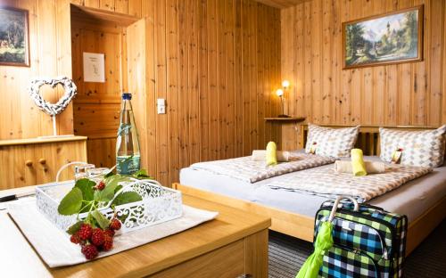 a bedroom with two beds and a wooden wall at Pension Haus Fürstenberg in Beierfeld