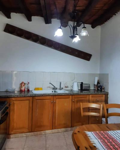 a kitchen with wooden cabinets and a sink and a table at John' s House in Omodos in Limassol