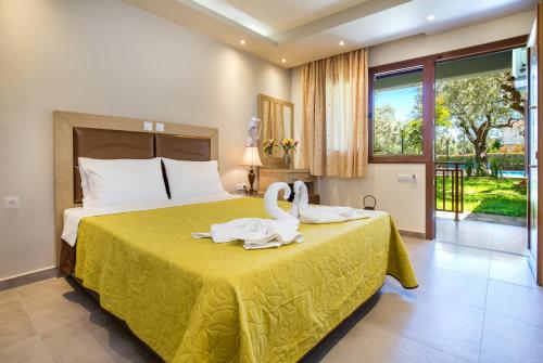 Dois cisnes sentados numa cama num quarto em Hotel Thetis em Limenas