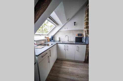a kitchen with white cabinets and a window at OHARA in Dinan