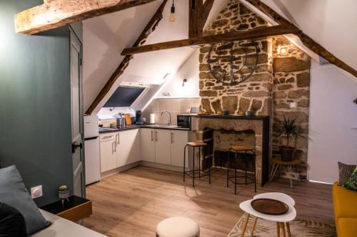 a kitchen and living room with a stone wall at OHARA in Dinan