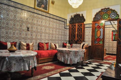 ein Wohnzimmer mit einem Sofa und 2 Tischen in der Unterkunft Riad Fattouma Kasba in Marrakesch