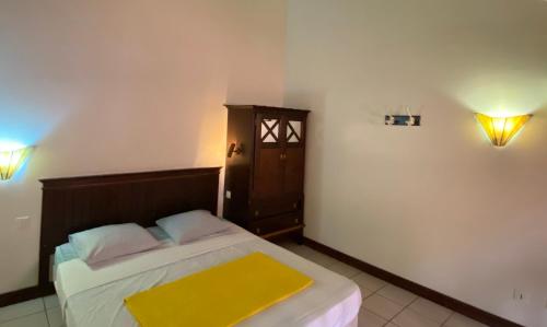 una camera da letto con un letto con una coperta gialla sopra di Appartement Vanille 2 a Sainte-Anne