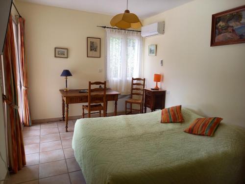 Schlafzimmer mit einem Bett, einem Tisch und einem Schreibtisch in der Unterkunft Villa au calme le brusc in Six-Fours-les-Plages