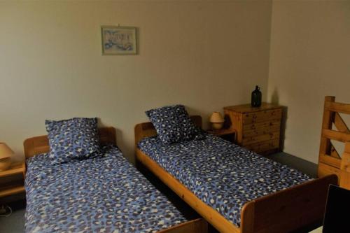 two twin beds in a room withthritisthritisthritisthritisthritisthritisthritisthritisthritis at Charmante maison de vacances proche mer commerces avec Piscine et wifi gratuit in Vaux-sur-Mer