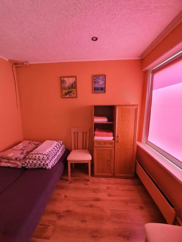 a small bedroom with a bed and a chair at Vidumgrāvja apartamenti in Ventspils